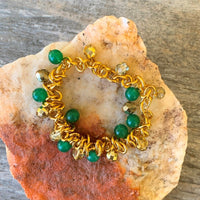 A bracelet made of Green Adventurine and gold crystals surrounded with gold chain