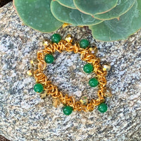 A bracelet made of Green Adventurine and gold crystals surrounded with gold chain