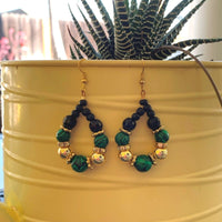 Earrings made of Malachite faceted beads in a teardrop with black & gold beads