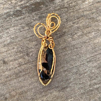 Pendant made of Ivory Copper Obsidian Oval stone with gold wire wrap; .5" w x 2" long, incl bail