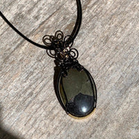 Pendant made of Large Apache Gold Pyrite Oval with Black and Gold wire wrap; 1: w x 2.25" long, incl bail. Come with 18" black cord with 2: extender