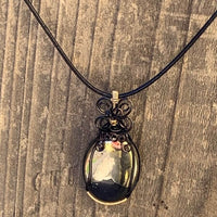 Pendant made of Large Apache Gold Pyrite Oval with Black and Gold wire wrap; 1: w x 2.25" long, incl bail. Come with 18" black cord with 2: extender