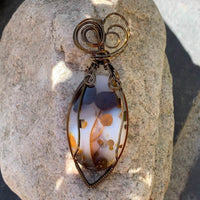 Pendant made of Large Polka Dot Jasper Oval stone with antique bronze wrap; 1" w x 2.75" long, incl bail