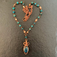 A necklace made of Oval Apatite stone with copper wrap on a rosary beaded necklace
