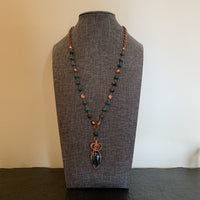 A necklace made of Oval Apatite stone with copper wrap on a rosary beaded necklace