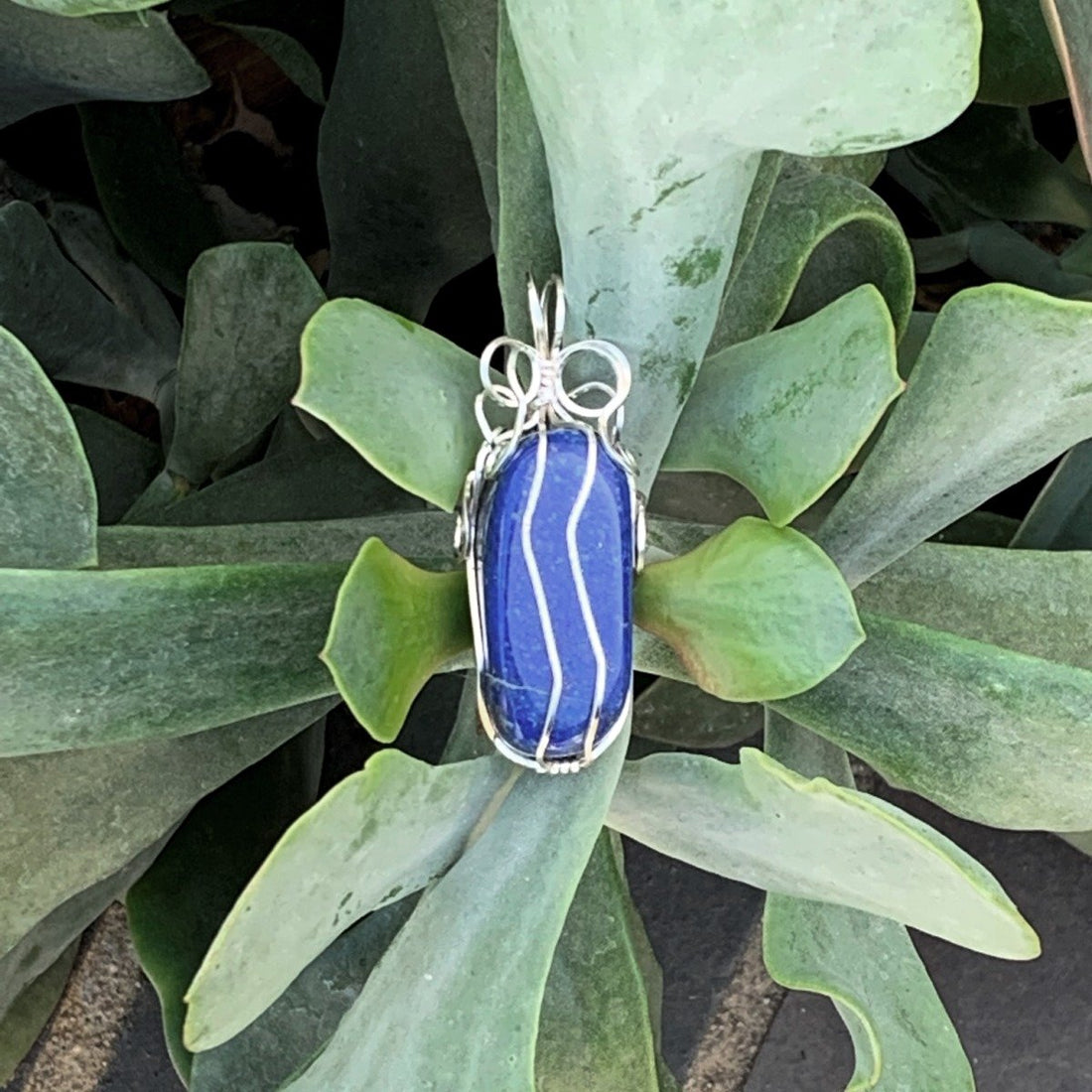Pendant made of Blue Rectangle Lapis Lazuli stone w/ silver wrap; .75" x 2.1" incl bail
