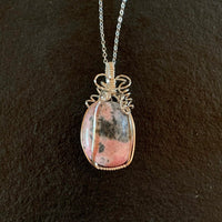 Pendant made of Pink & Grey Rhodonite oval stone with silver wrap; 1" w x 2" h incl bail