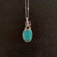 Pendant made of Turquoise Dyed Magnesite with silver wrap.75" w x 2" h, incl bail