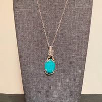Pendant made of Turquoise Dyed Magnesite with silver wrap.75" w x 2" h, incl bail