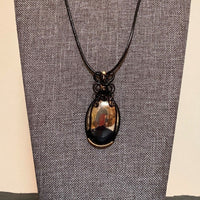 Pendant made of Large Apache Gold Pyrite Oval with Black and Gold wire wrap; 1: w x 2.25" long, incl bail. Come with 18" black cord with 2: extender