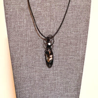 Pendant made of Ivory Copper Obsidian Oval stone, White Magnesite accent cabochon with black wire wrap; .5" w x 1 7/8" long, incl bail; comes with a 18" black cord with 2 " extender
