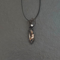 Pendant made of Ivory Copper Obsidian Oval stone, White Magnesite accent cabochon with black wire wrap; .5" w x 1 7/8" long, incl bail; comes with a 18" black cord with 2 " extender