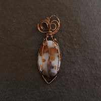Pendant made of Large Polka Dot Jasper Oval stone with antique bronze wrap; 1" w x 2.75" long, incl bail