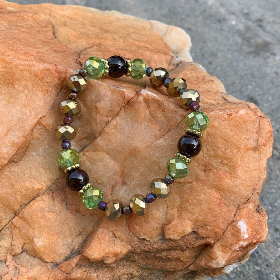 A bracelet made of Garnet beads, Green & gold rondel crystals on elastic