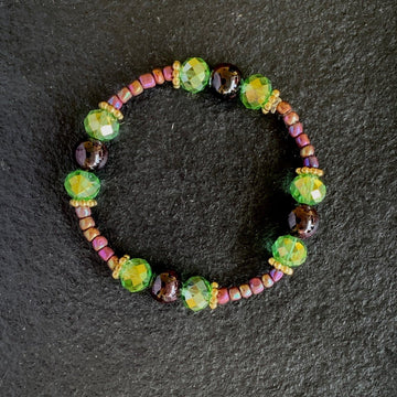 A bracelet made of Garnet beads, green crystals and aurora seed beads