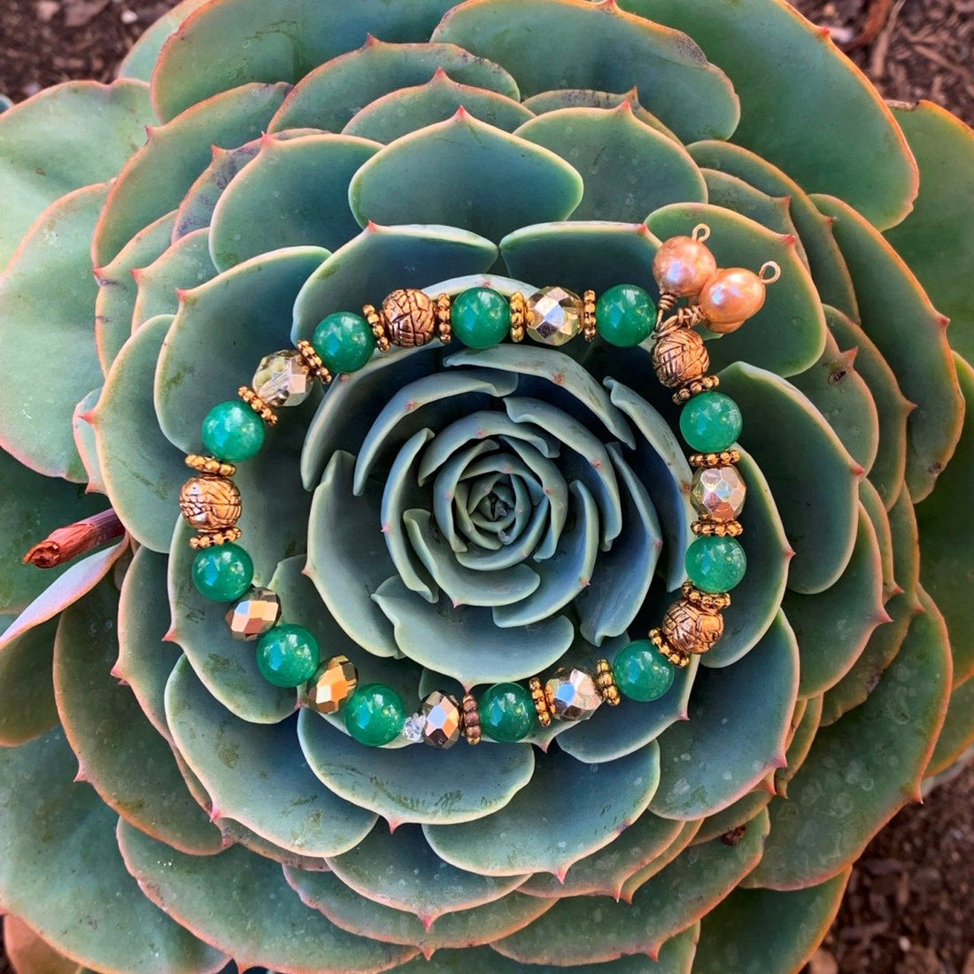 A bracelet made of Green Adventurine beads with gold pears, crystal & metal beads