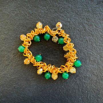 A bracelet made of Green Adventurine and gold crystals surrounded with gold chain