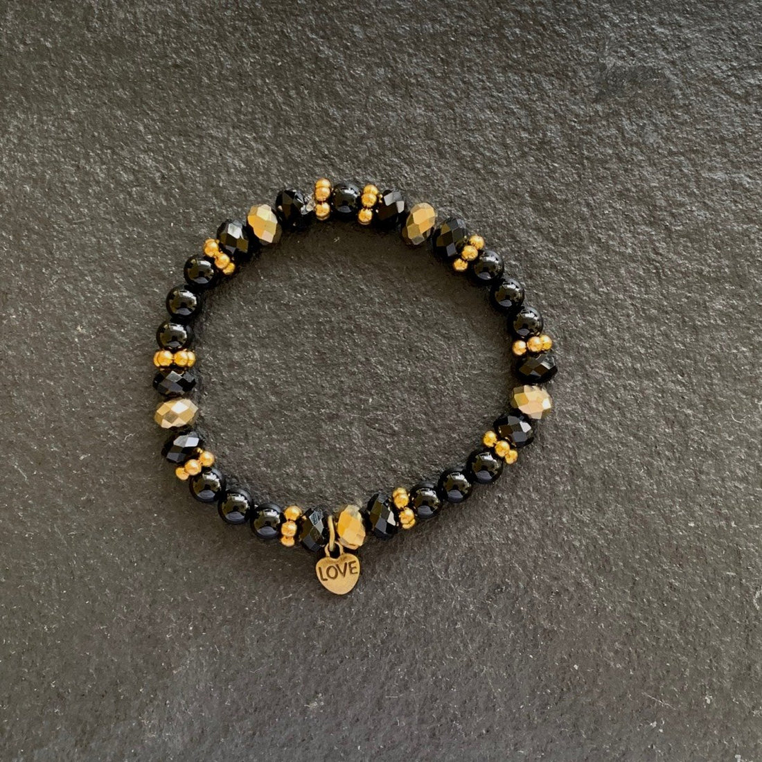 A bracelet made of Black onyx rounds with gold rondels