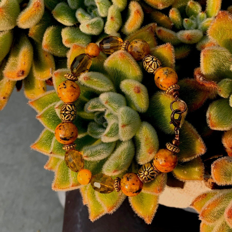 A bracelet made of Orange spotted Jasper w/gold & bronze crystals & bronze spring clasp