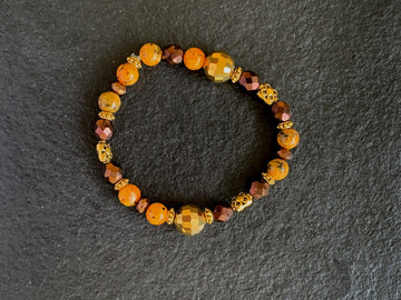 A bracelet made of Orange spotted Jasper w/gold & bronze crystals & gold disco beads
