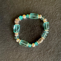 A bracelet made of Aqua Quartz rectangle barrels with silver crystals & beads