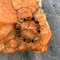 A bracelet made of Gold Barrel Crystals with black rondels and antique gold beads