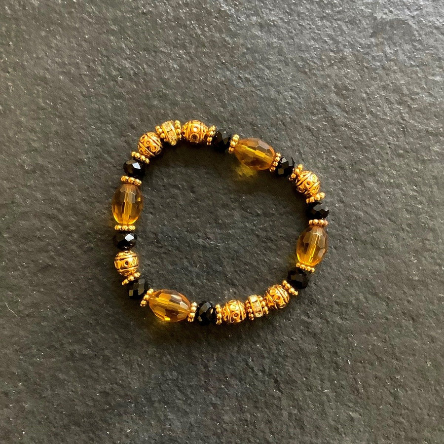 A bracelet made of Gold Barrel Crystals with black rondels and antique gold beads