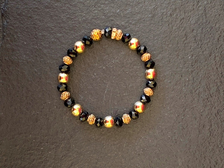 A bracelet made of Gold beads with black & gold rondels