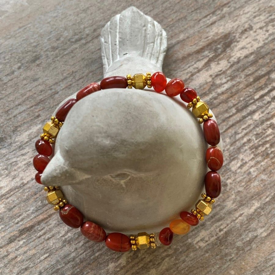 A bracelet made of Red Poppy Jasper ovals with gold hexagon beads on elastic