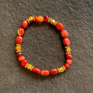 A bracelet made of Red Poppy Jasper ovals with gold hexagon beads on elastic