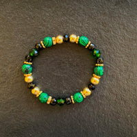 A bracelet made of Malachite faceted rounds with black & green crystals & gold beads on elastic