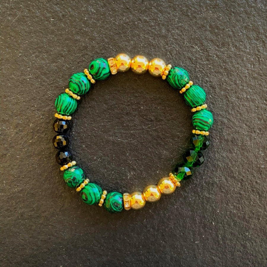 A bracelet made of Malachite faceted rounds with black & green crystals & gold beads on elastic