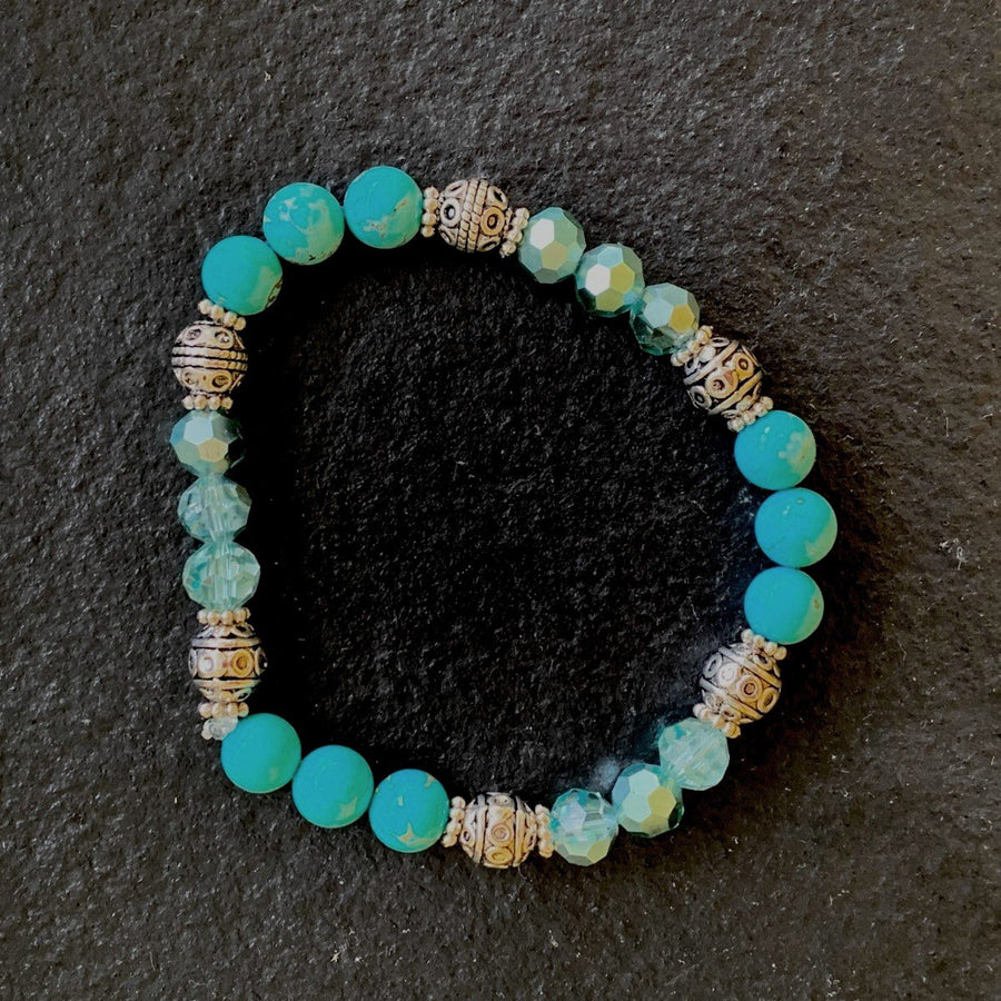 A bracelet made of Turquoise rounds with turquoise crystals & silver barrel beads on elastic