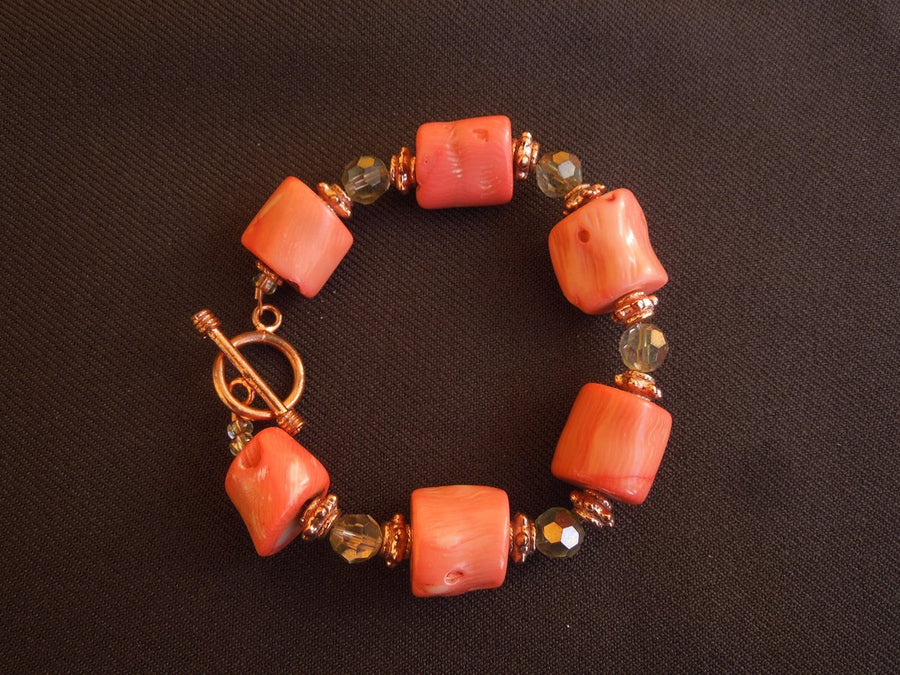 A bracelet made of Peach coral Barrels with copper crystals and toggle clasp