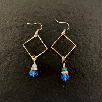 Earrings made of Two Toned Blue crystals & rondels hanging from a silver square drop