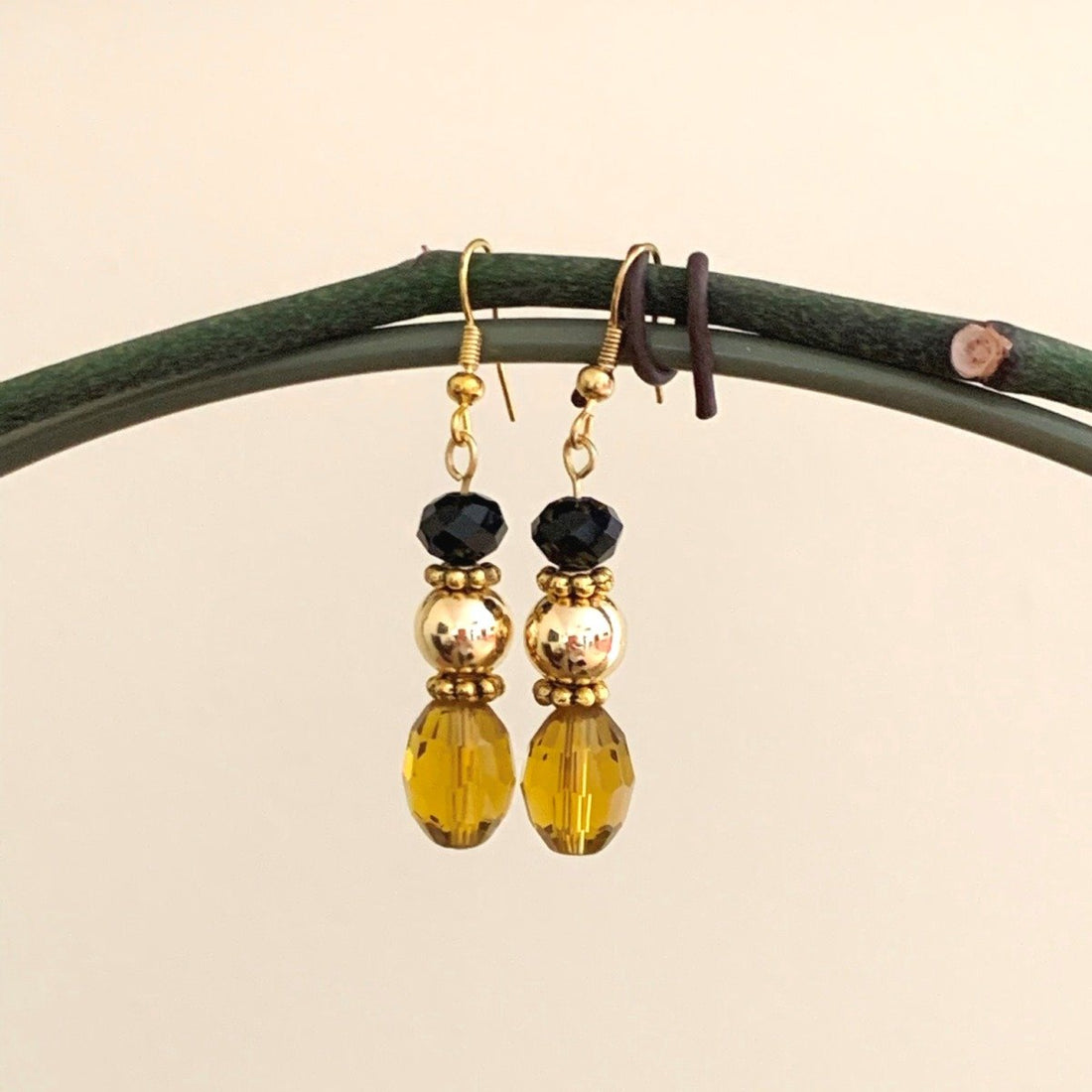 Earrings made of Gold crystal barrels with gold bead & black rondel