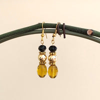 Earrings made of Gold crystal barrels with gold bead & black rondel