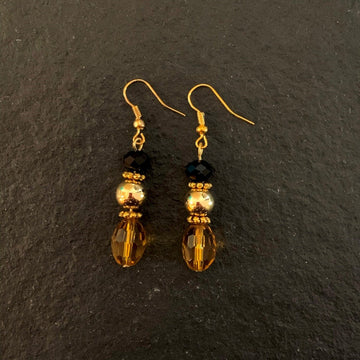 Earrings made of Gold crystal barrels with gold bead & black rondel