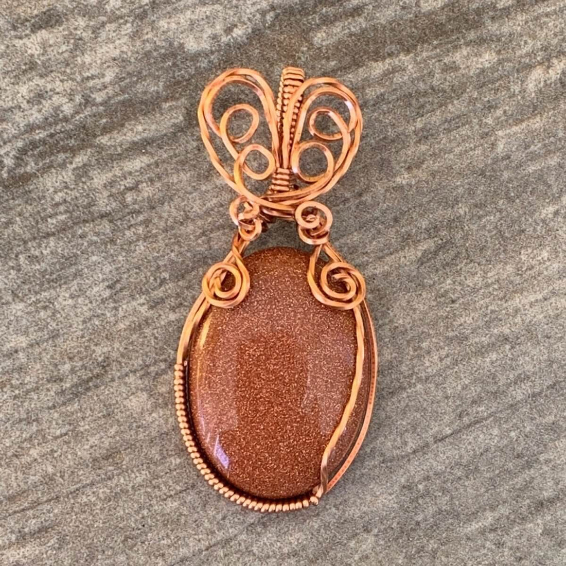 Pendant made of Golden Sunstone Oval Stone with Copper wire wrap; 1' w x 2 1/8" long, incl bail