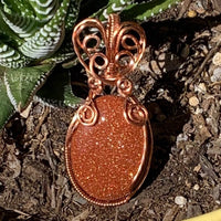 Pendant made of Golden Sunstone Oval Stone with Copper wire wrap; 1' w x 2 1/8" long, incl bail