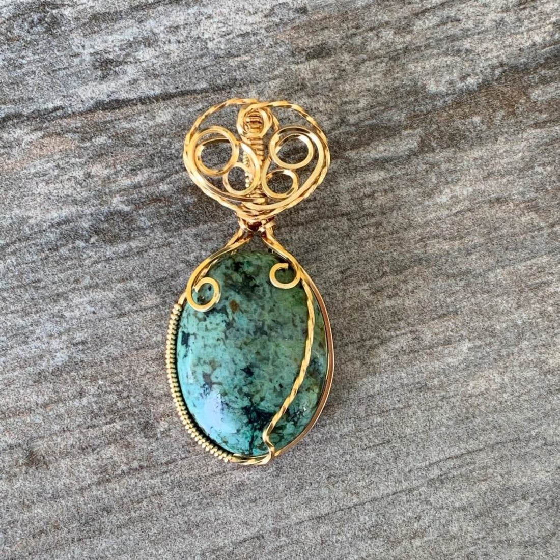 Pendant made of African Turquoise Oval Stone with Gold wire wrap; 1" w x 2 1/8" Long