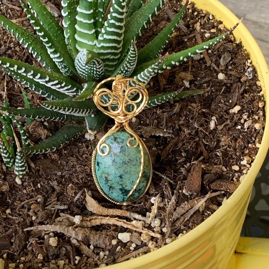 Pendant made of African Turquoise Oval Stone with Gold wire wrap; 1" w x 2 1/8" Long