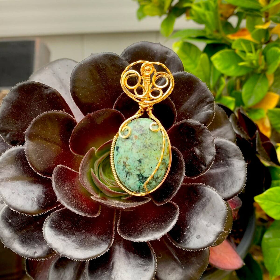 Pendant made of African Turquoise Oval Stone with Gold wire wrap; 1" w x 2 1/8" Long