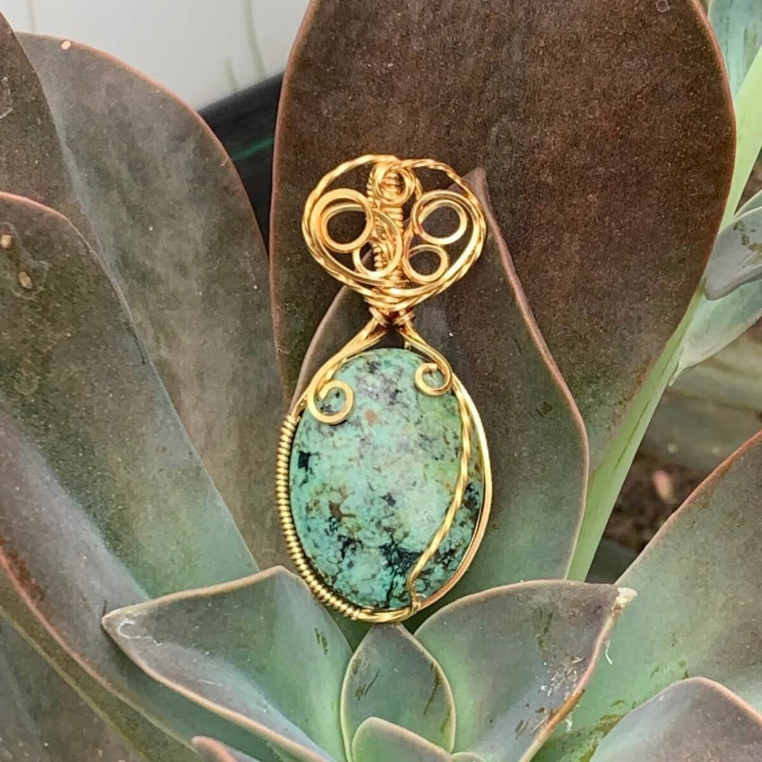 Pendant made of African Turquoise Oval Stone with Gold wire wrap; 1" w x 2 1/8" Long