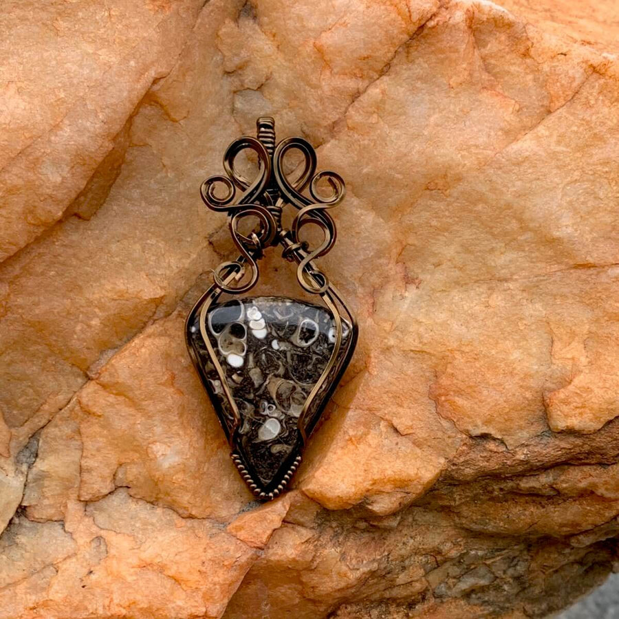 Pendant made of Turritella Triangle Agate with Bronze wire wrap; 1" w x 2 1/8" long incl bail