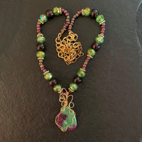 A necklace made of Green & Purple Ruby in Zoisite pendant with garnet beads and crystals