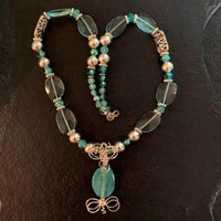 A necklace made of Aqua quartz faceted ovals w/turquoise crystals and silver beads