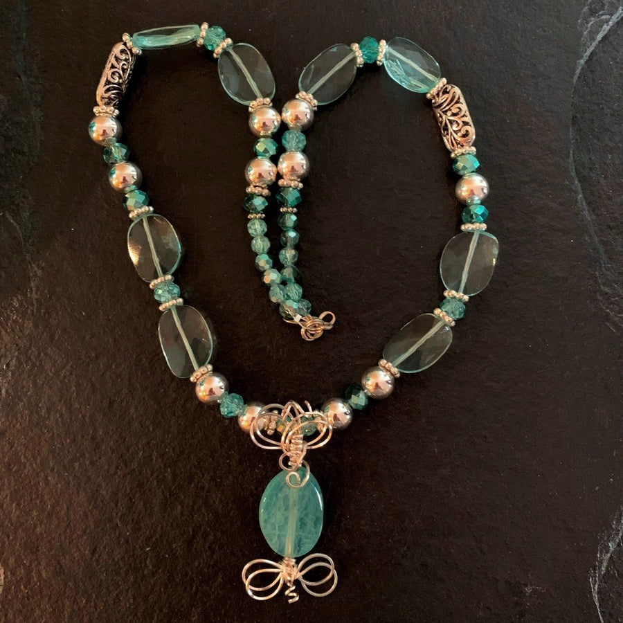 A necklace made of Aqua quartz faceted ovals w/turquoise crystals and silver beads