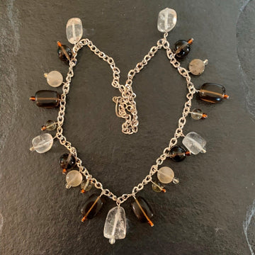 A necklace made of Clear & Smoky Quartz dangle from silver chain