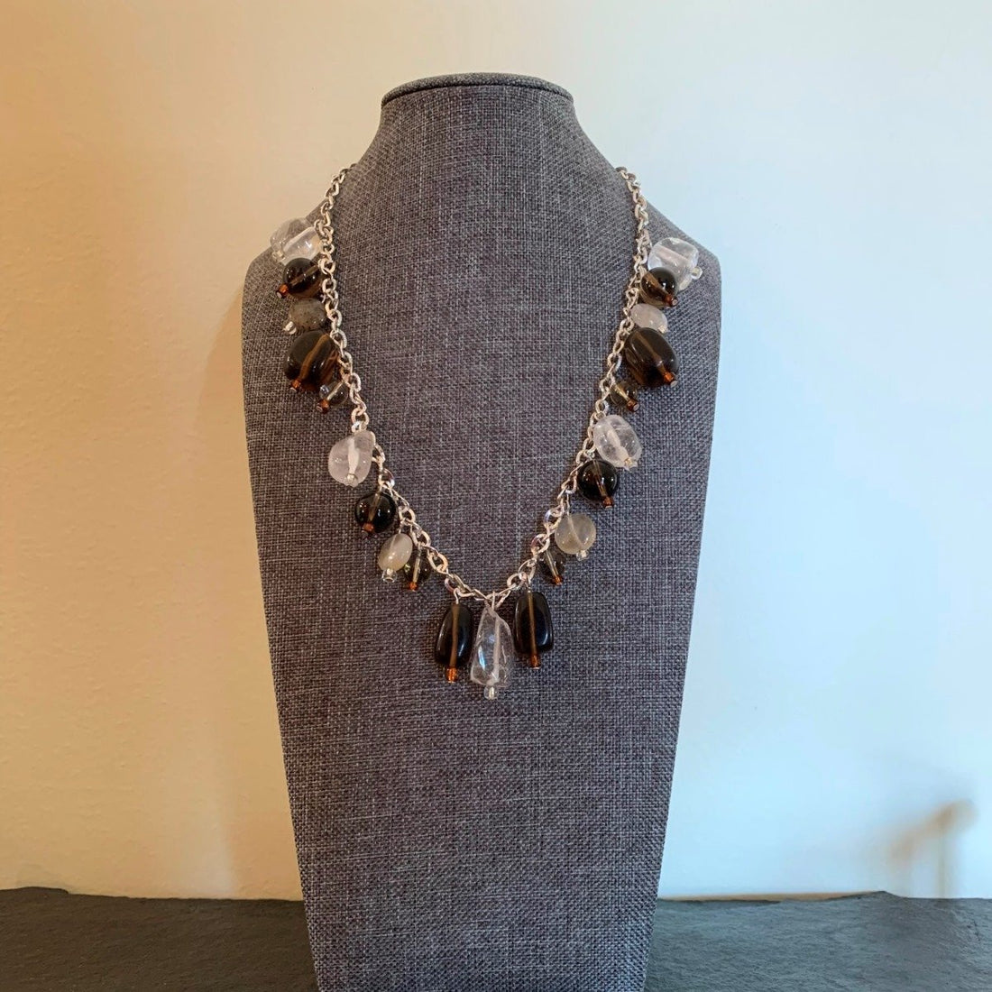 A necklace made of Clear & Smoky Quartz dangle from silver chain